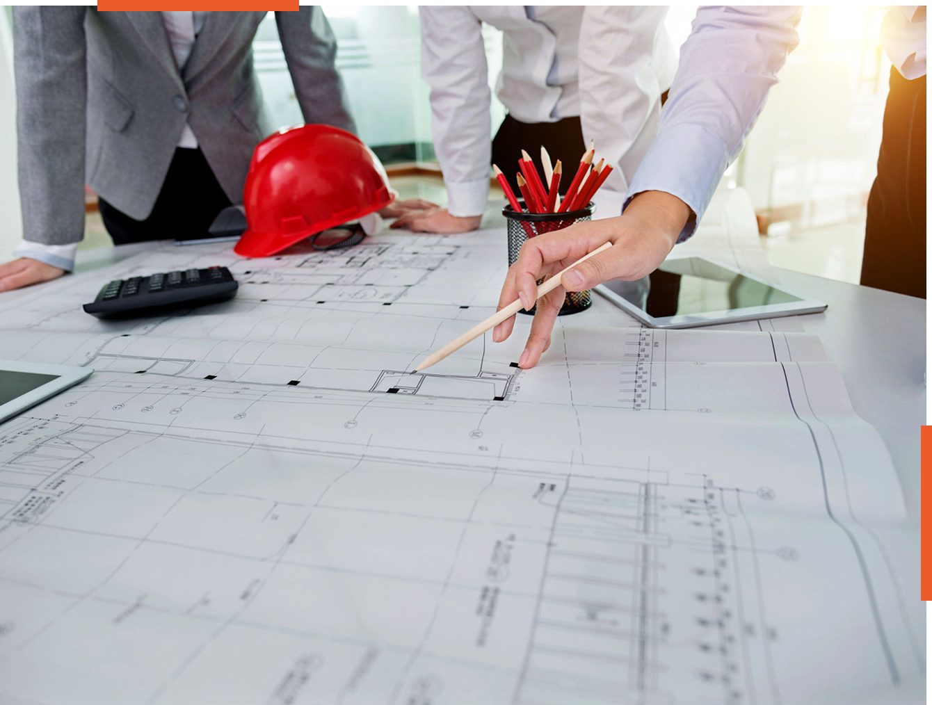 Architects reviewing building blueprints on table.