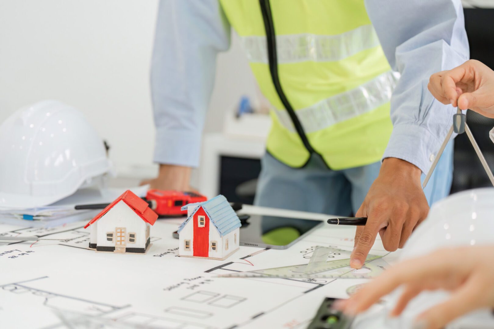 Architects reviewing blueprints with model houses.